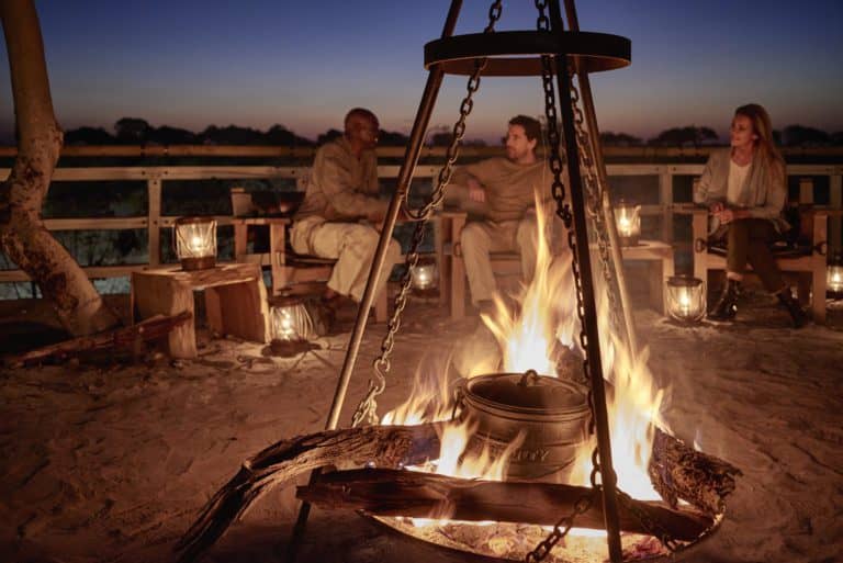Belmond Safaris, Savute Elephant Lodge - guests enjoying the fire place