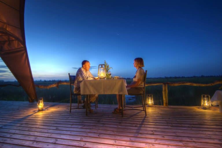 Private dinner under night sky on wooden deck at Okuti