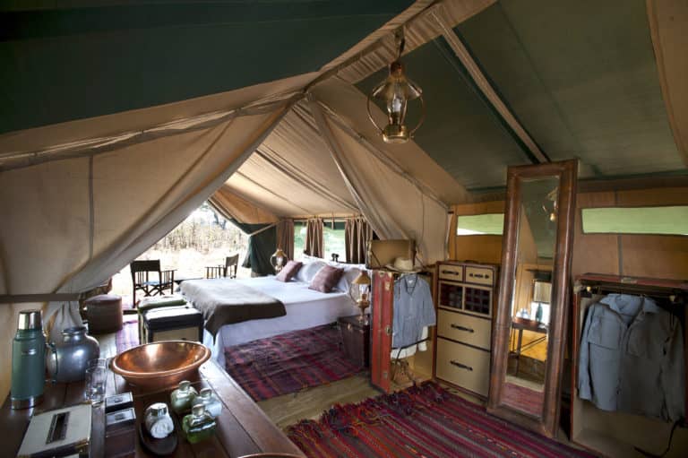 Luxurious guest tent with carpets and copper basin at Selinda Explorers Camp